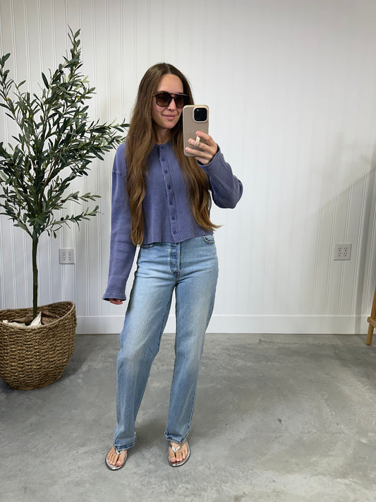 Woman taking a mirror selfie wearing a purple shirt and light blue jeans in a room with a plant and white wall. Slate Blue Waffle Top