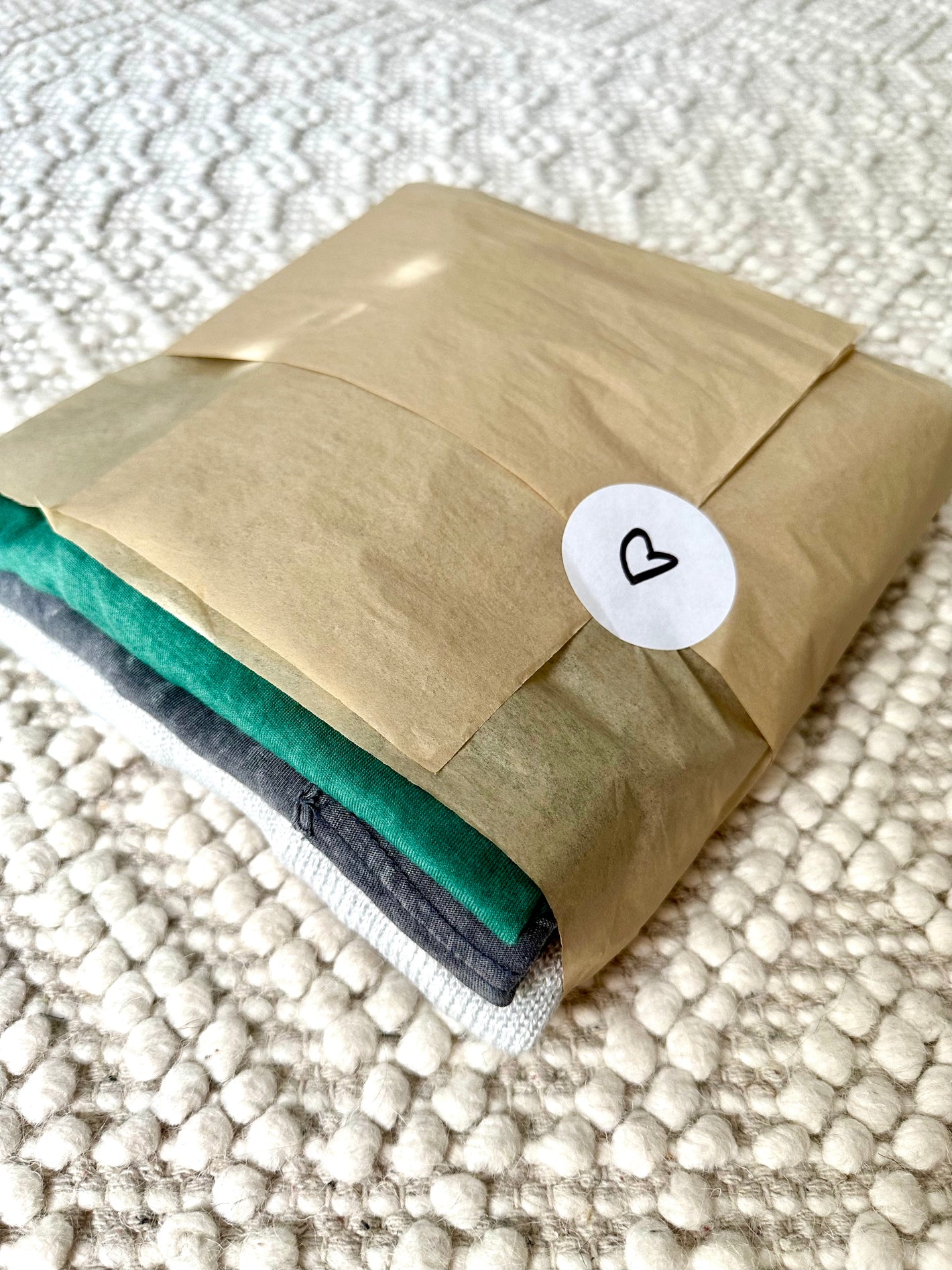 stack of clothing wrapped in tissue paper. customer clothing order.